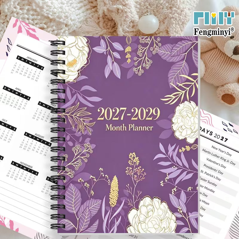 Tuotekuva  2027-2029 Month Planner -kalenterista, jossa on violetti kukkakuvioitu kansi ja musta kierreosa.   