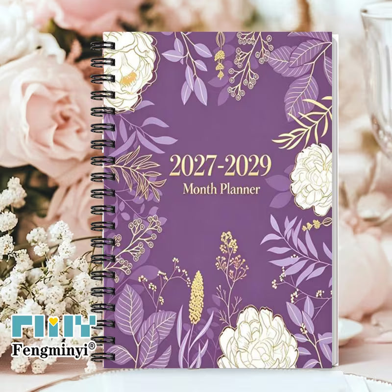 Tuotekuva  2027-2029 Month Planner -kalenterista, jossa on violetti kukkakuvioitu kansi ja musta kierreosa.   