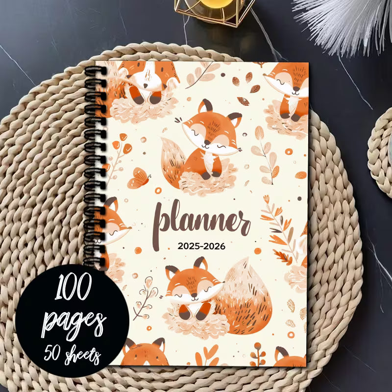 Kalenteri vuodelle 2025–2026 söpöillä ketuilla ja kukka-asetelmilla