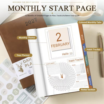 Tuotekuva lilasta A5-kokoisesta Daily & Monthly Planner Pro 2027 -kalenterista, jossa on pehmeä tekonahkakansi, värikkäät kuukausi-indeksit ja lila kirjoituskynä.   