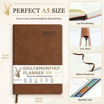 Tuotekuva lilasta A5-kokoisesta Daily & Monthly Planner Pro 2027 -kalenterista, jossa on pehmeä tekonahkakansi, värikkäät kuukausi-indeksit ja lila kirjoituskynä.   