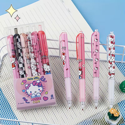 Kuusi värikästä Hello Kitty -geelikynää aseteltuna avatun lahjapakkauksen päälle pastellinsävyisellä kirjoituspöydällä.