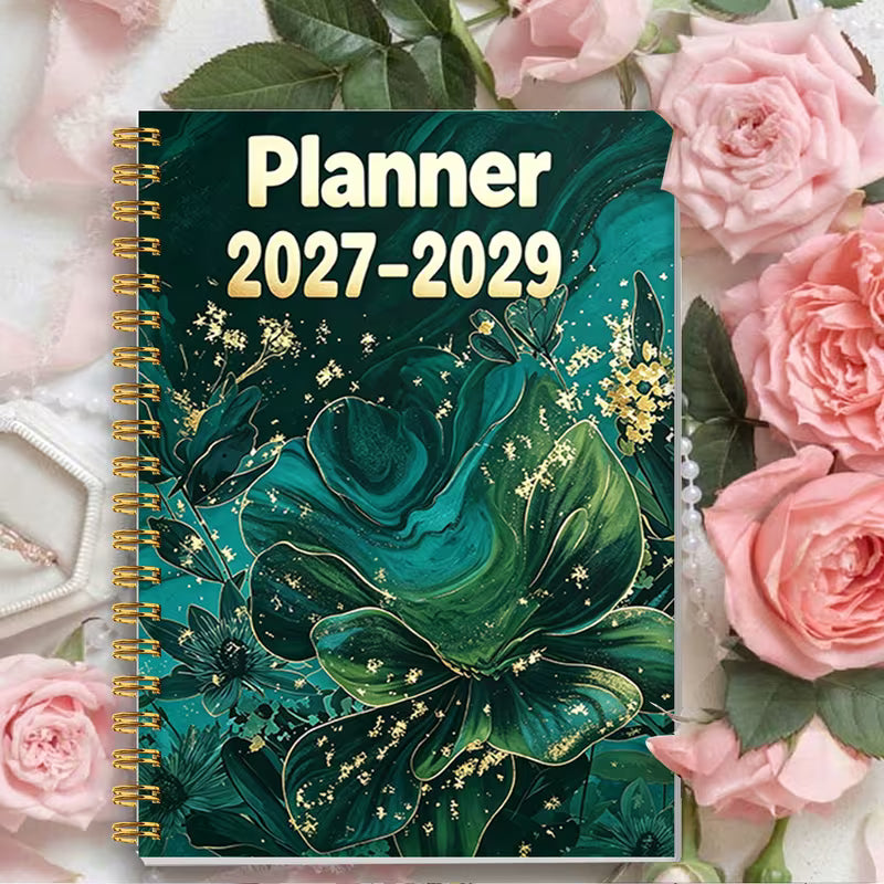 Tuotekuva Planner 2027-2029 -kalenterista, jossa on tummanvihreä fluid art -tyylinen kukkakansi kultahippusilla ja kultainen kierresidonta.   