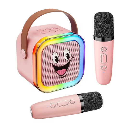Tuotekuva vaaleanpunaisesta hymynaamaisesta Bluetooth-karaokekaiuttimesta, jossa on värikkäät valot, kantokahva ja kaksi langatonta mikrofonia.   