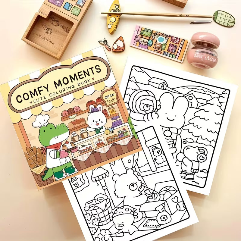 Lähikuva avatusta Comfy Moments -värityskirjasta, jossa on kotoisa piirros pehmeästä nojatuolista ja kirjapinosta. Sivun vieressä on laadukkaita pastellisävyisiä kyniä.