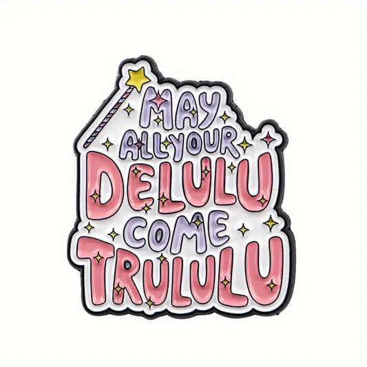 Valkoinen emalinasta, jossa on vaaleanpunaisella ja lilalla kirjoitettu teksti May all your delulu come trululu, taikasauva ja keltaisia tähtiä