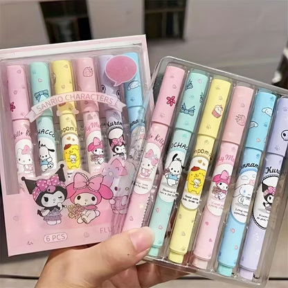 Kuusi pastellinväristä korostuskynää, joissa on Hello Kitty- ja Sanrio-hahmojen kuvia. Kynät on aseteltu avatun muistikirjan viereen valkoisella pöydällä