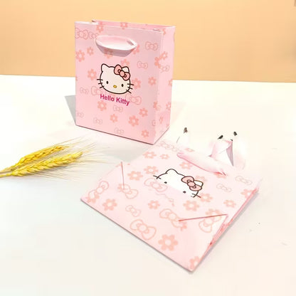 Söpö vaaleanpunainen Hello Kitty -lahjarasia ja siihen sopiva kantokassi asetettuna tasolle. Rasia on avattu osoittamaan, että se on valmis korua varten.