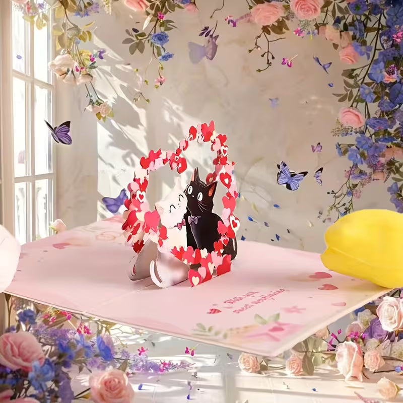 Avattu vaaleanpunainen 3D pop-up -kortti, jossa musta ja valkoinen kissa istuvat sydänkaaren alla ja teksti 'With you, sweet overflowing