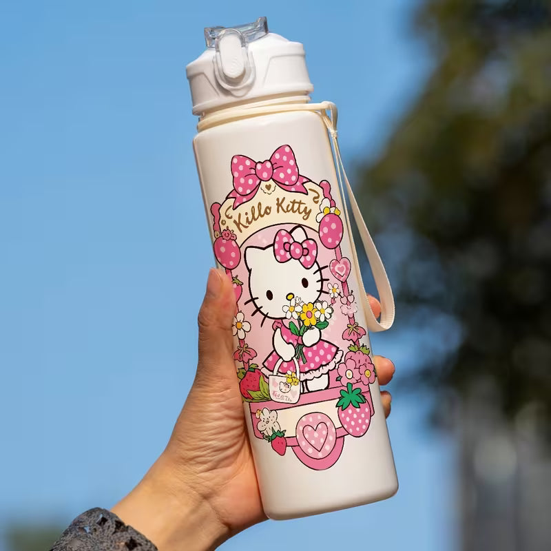 Käsi pitelee suloista pinkkiä Hello Kitty -juomapulloa, jossa on sisäänrakennettu pilli, aurinkoisessa puutarhassa.