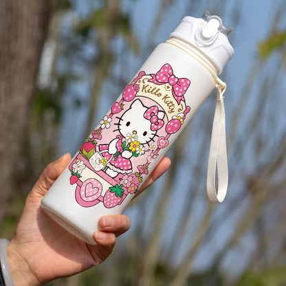 Käsi pitelee suloista pinkkiä Hello Kitty -juomapulloa, jossa on sisäänrakennettu pilli, aurinkoisessa puutarhassa.