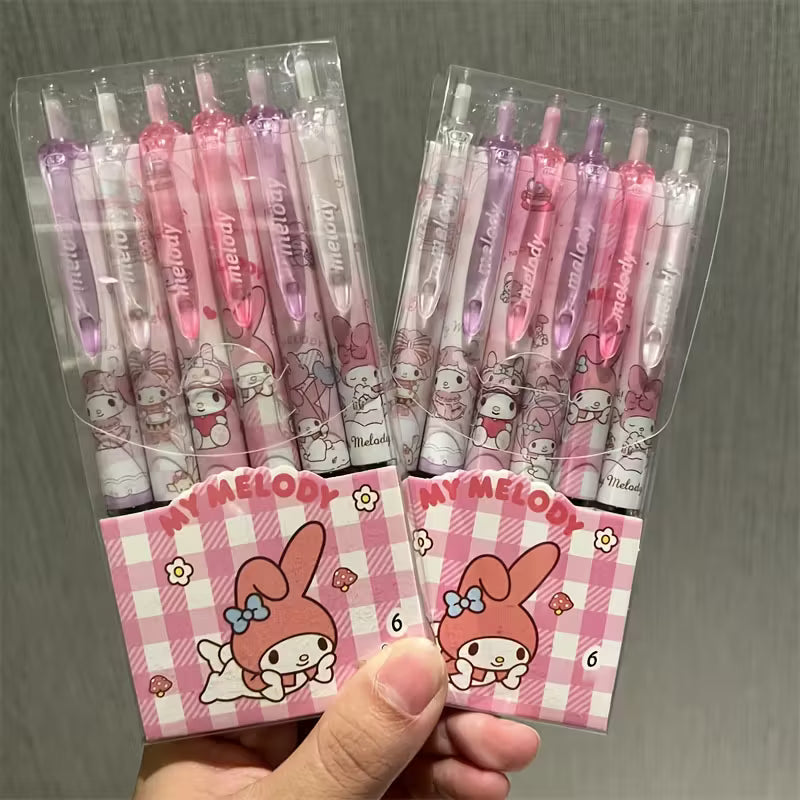 Käsi kirjoittaa siistiä tekstiä vaaleanpunaisella Sanrio-geelikynällä, jossa on Kuromin ja My Melodyn kuvia.