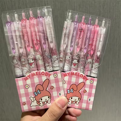 Käsi kirjoittaa siistiä tekstiä vaaleanpunaisella Sanrio-geelikynällä, jossa on Kuromin ja My Melodyn kuvia.
