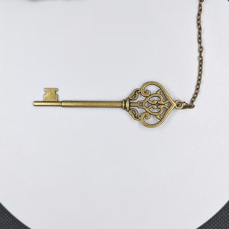 Elegantti metallinen höyhenen muotoinen kirjanmerkki, jossa on hienostuneita kaiverruksia, lepäämässä vanhan nahkakantisen kirjan sivujen päällä.