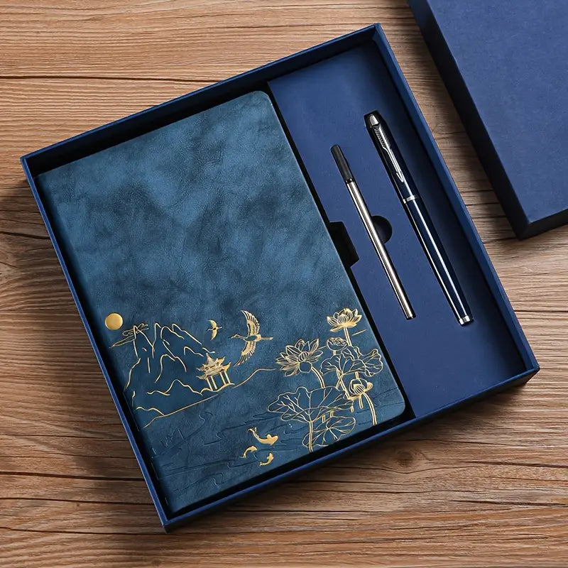 Ylellinen sininen lahjasetti, joka sisältää kultakuvioidun muistikirjan, elegantin kynän ja täyttöpakkauksen tyylikkäässä rasiassa